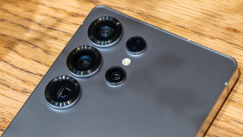 Close-up of the Galaxy S25 Ultra rear camera array on a worn wooden table